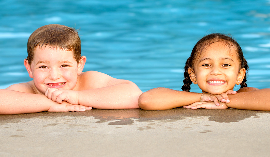 Niño y niña sonrientes en la piscina